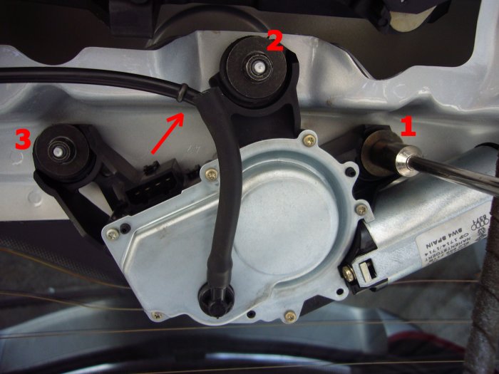 Den Wasserschlauch abziehen (Pfeil) und die 3 Muttern abschrauben